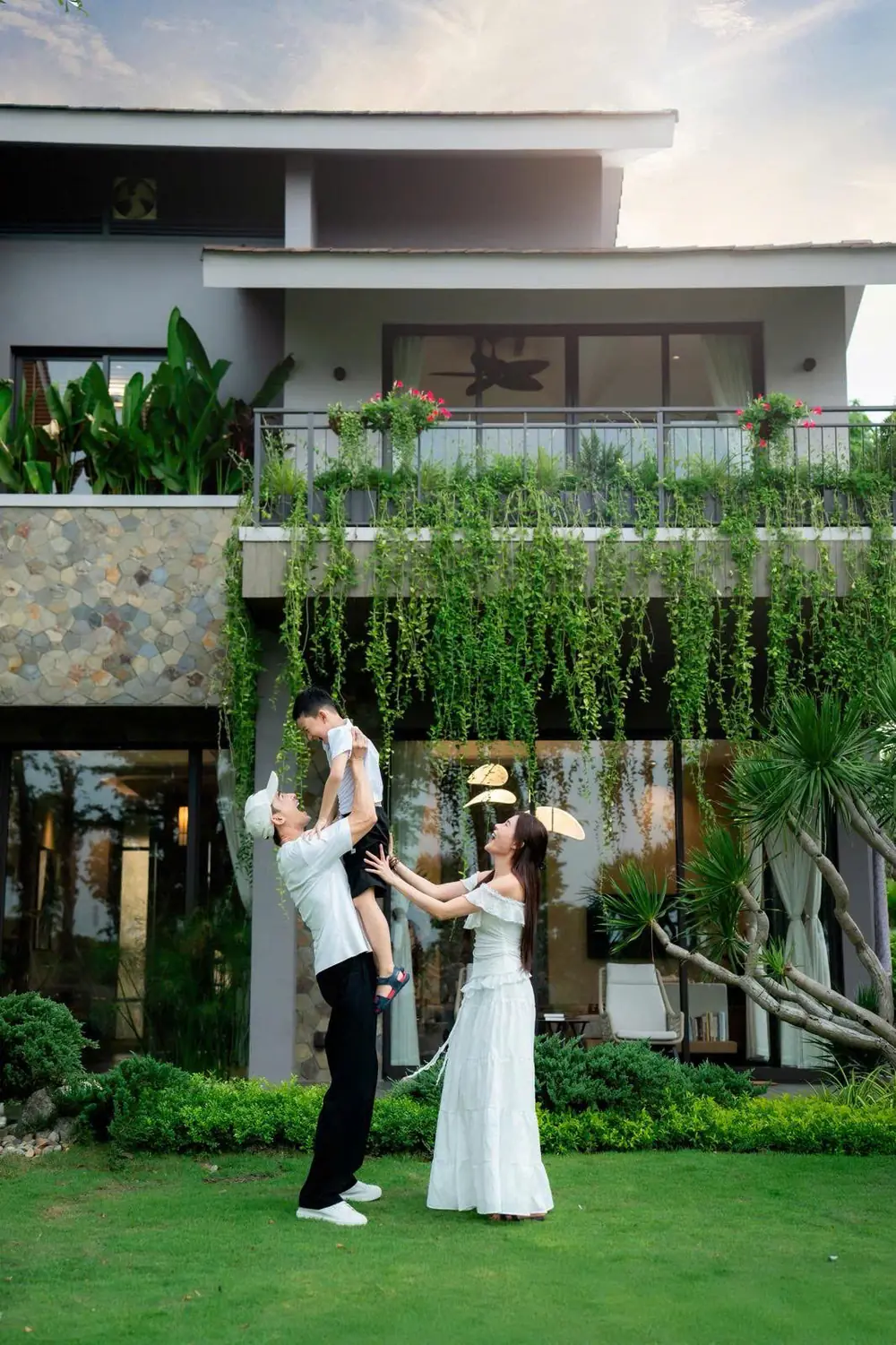Gia đình chơi cùng con trước sân vườn nhà tại Eco Retreat Rừng Phượng